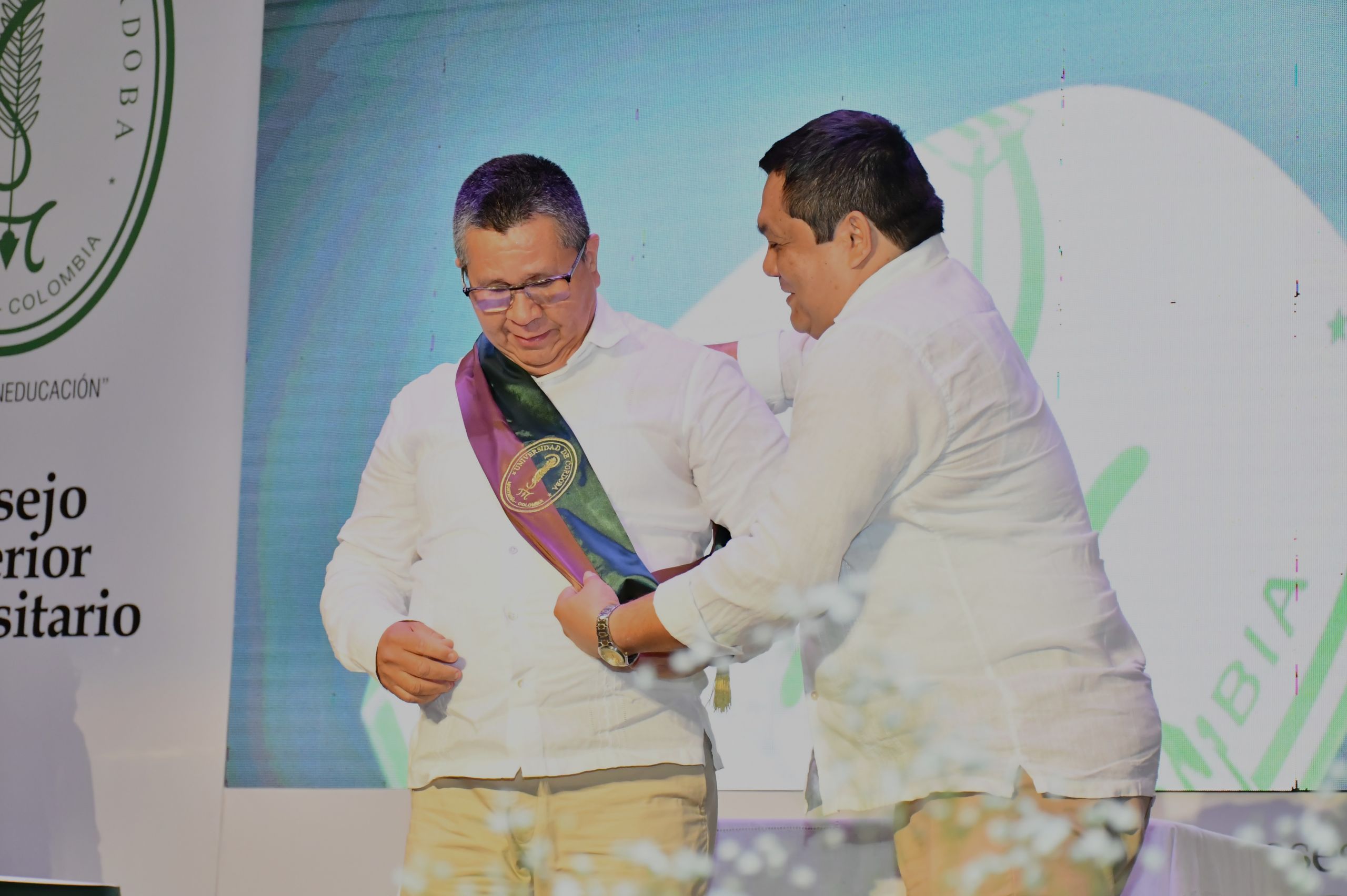 El profesor Torres Oviedo recibe la banda de manos del presidente del Consejo Superior Universitario, licenciado Jorge Espitia Solera.